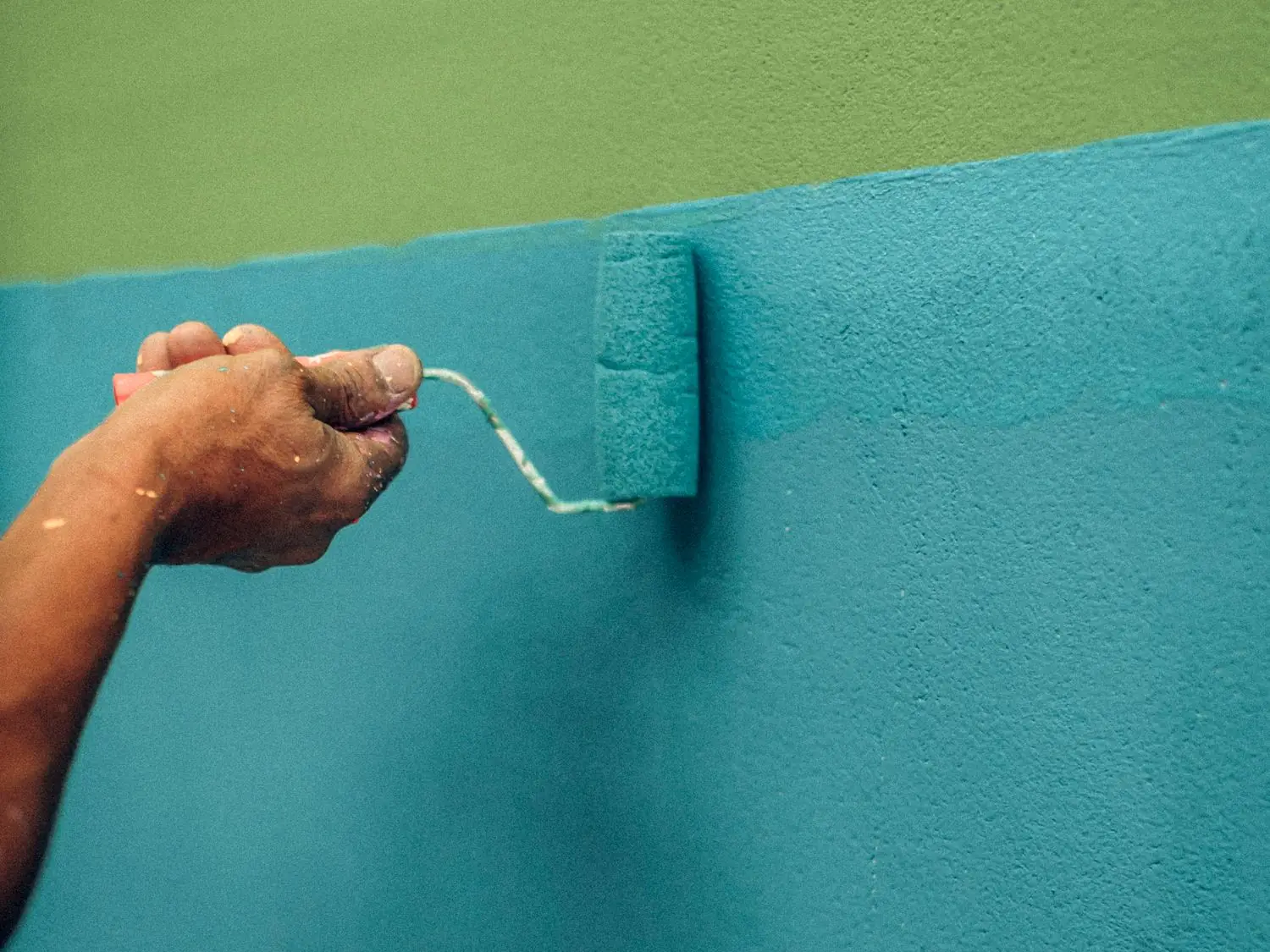 Painter rolling a finish coat onto a wall