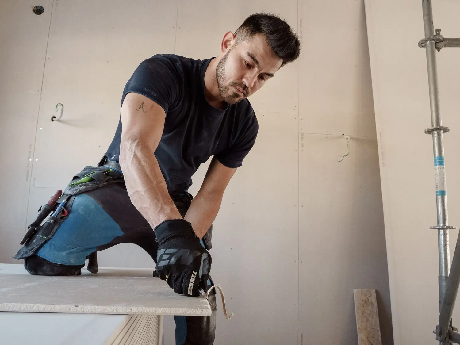 Worker cutting board during an interior remodel